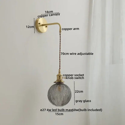 Modern glass copper led wall sconce with brass-finished copper arm and adjustable wire suspending textured gray glass globe