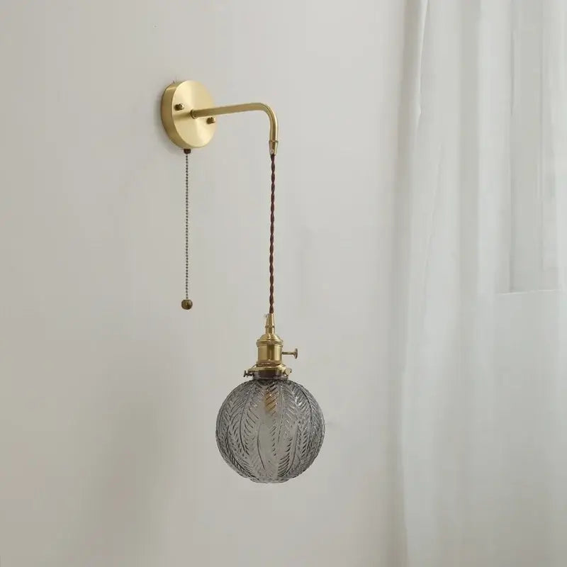 Modern glass copper led wall lights featuring a vintage brass arm and ornate gray glass globe pendant sconce for bedroom use