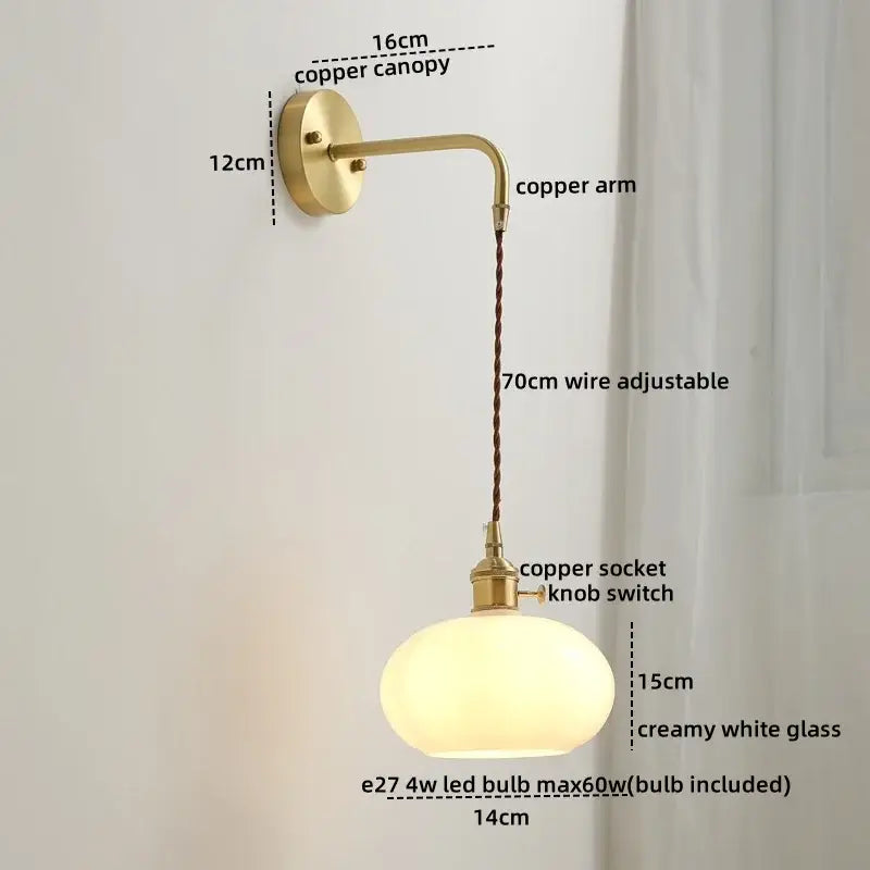 A vintage-style copper led wall light with a curved arm, braided wire suspension, and creamy white glass globe