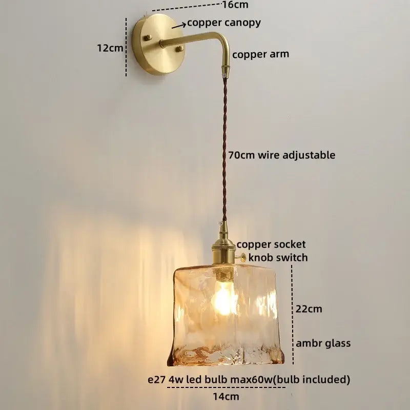 A warm amber glass copper led wall light with textured surface and brass copper hardware for bedroom use