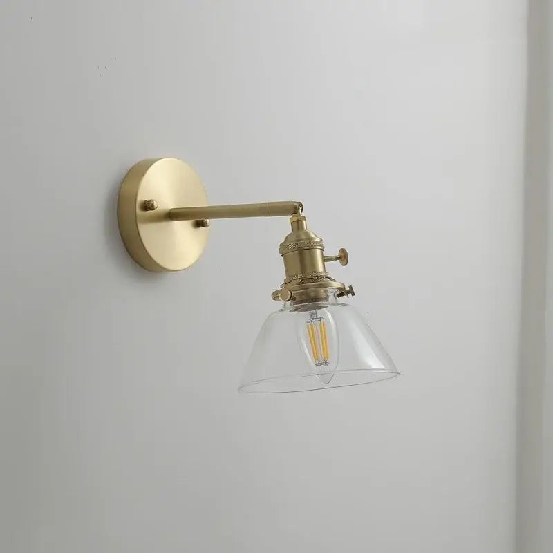 Brass-finished wall lights with clear glass copper led shade and exposed filament bulb for bedroom reading