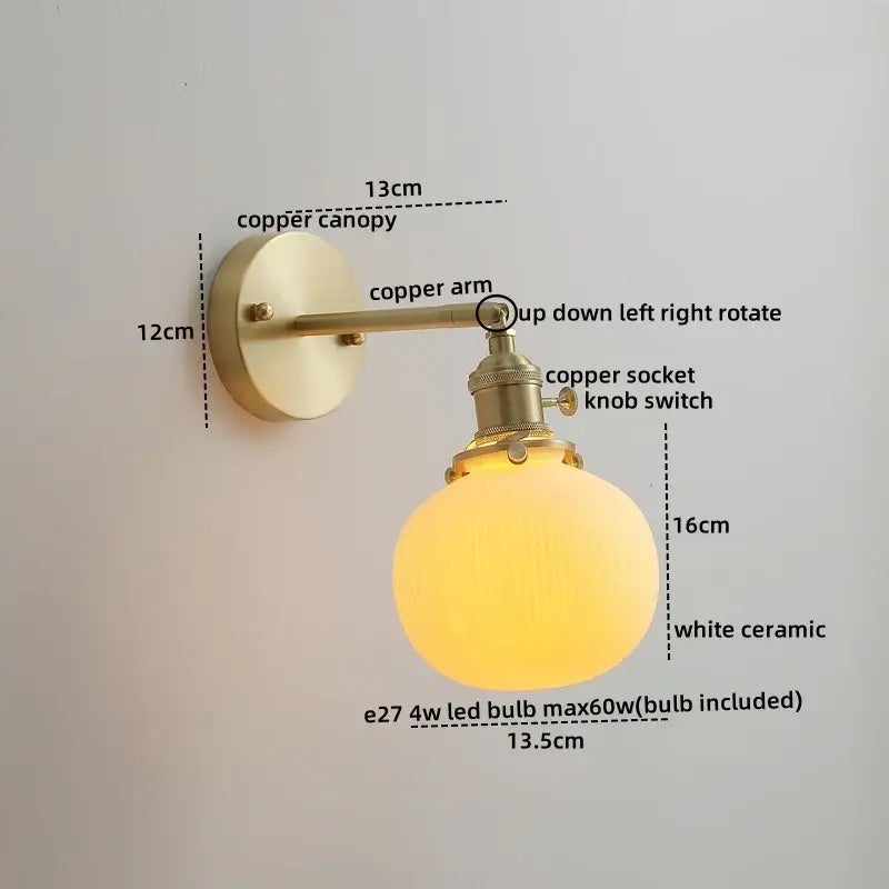 A warm glowing white ceramic globe lamp with brass copper led wall lights for bedroom reading