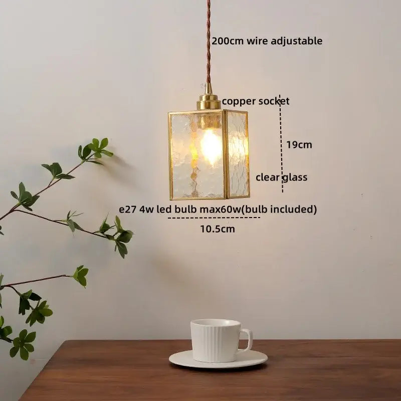 Modern glass copper pendant light with brass frame, clear textured glass panels, and adjustable copper socket for dining room