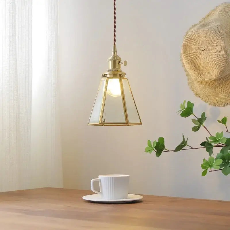 Modern glass copper pendant light with brass frame and warm glow ideal for dining room or kitchen island lighting