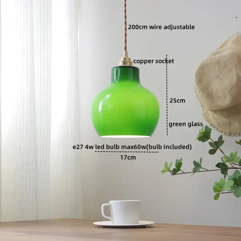 A vibrant green glass copper pendant light with copper socket and braided wire for dining room or kitchen island