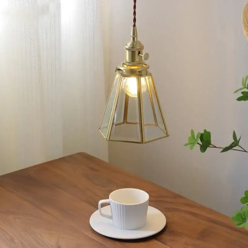 Brass-framed modern glass copper pendant light with warm glow for dining room and kitchen island lighting