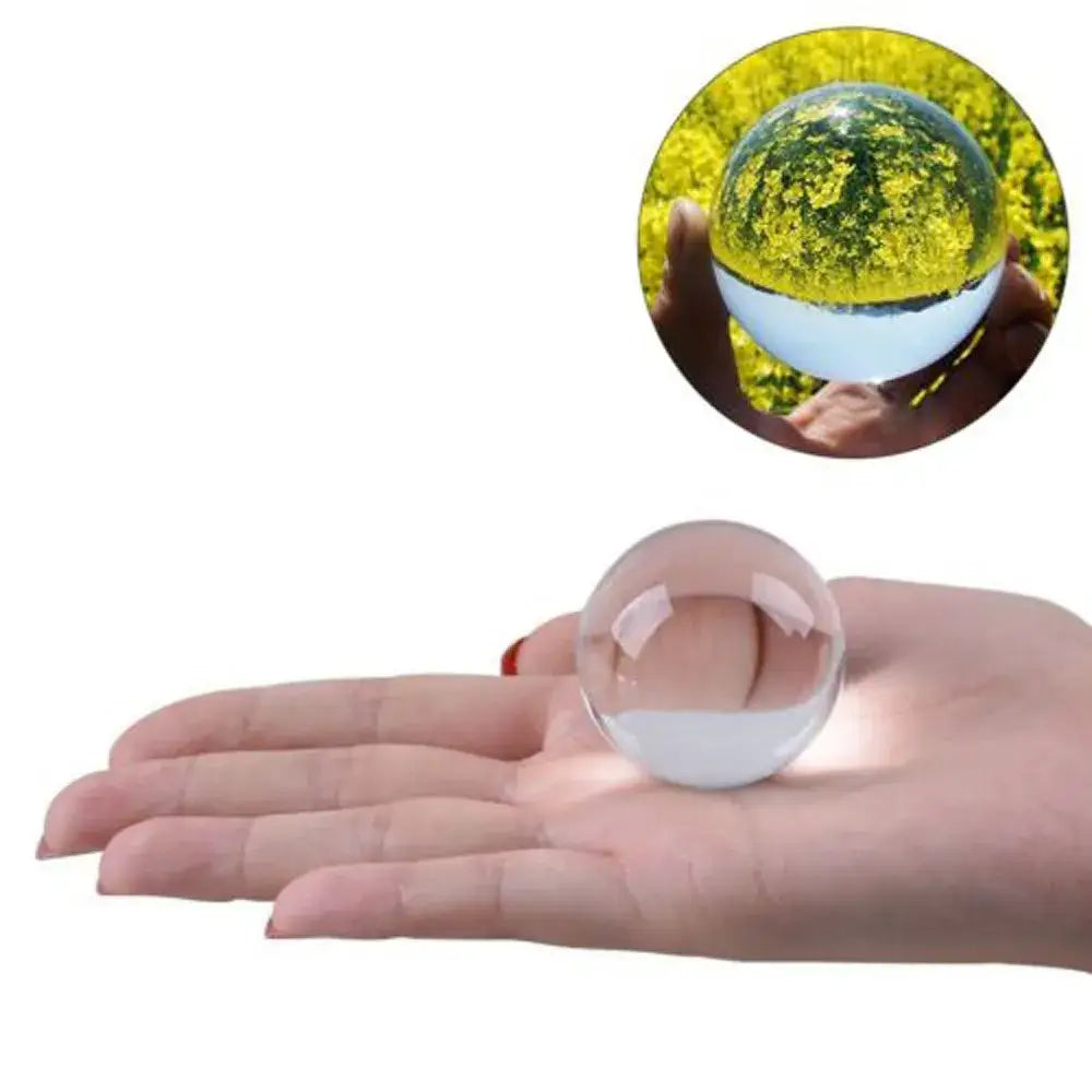 Modern glass crystal ball held in hand displaying its transparent and reflective surface for living room decor use