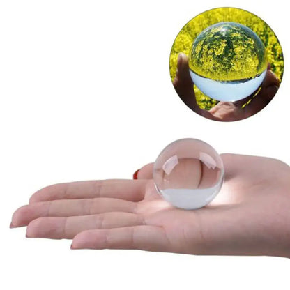 Clear glass crystal ball held in hand showcasing transparent reflective surface for modern living room decor
