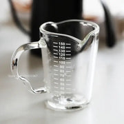 Modern glass cup measuring jug with clear glass, wooden handle, and milliliter markings for milk latte use
