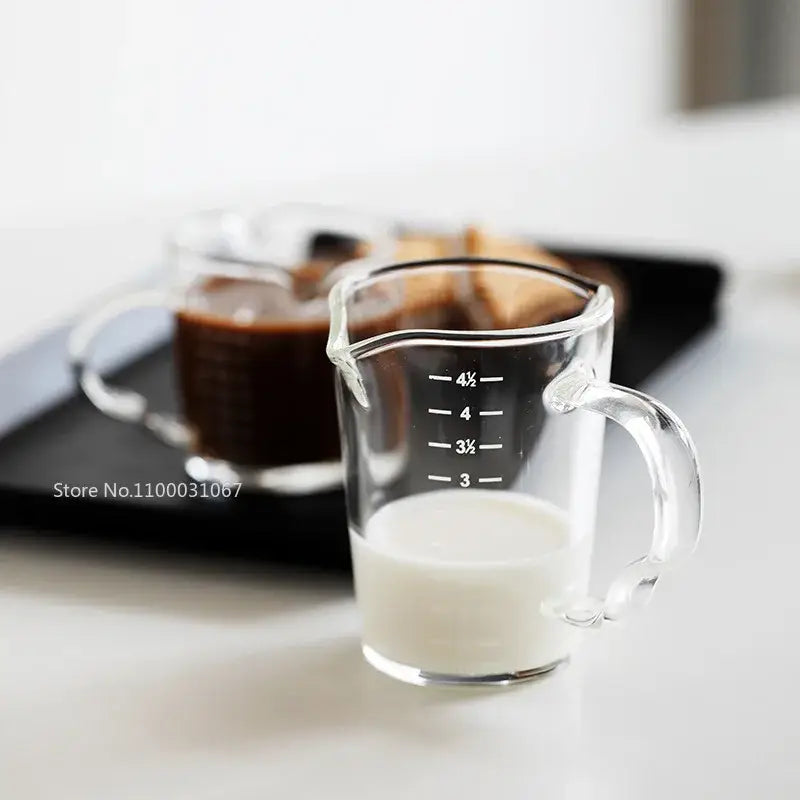 Modern glass cup with wooden handle measuring jug filled with milk as a milk latte jug kitchen tool