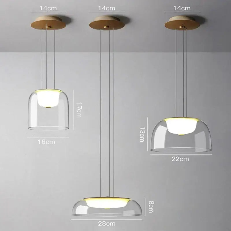 Three modern glass pendant lights with clear domes and wooden fixtures featuring warm LED glow for dining room use