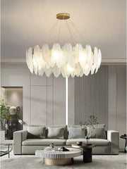 A modern glass feather chandelier with translucent leaf-shaped panels and brass fixture for living room pendant lighting