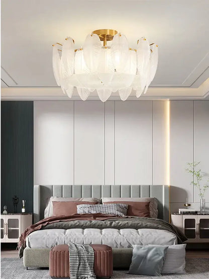 Modern glass feather chandelier featuring white glass feathers and a gold-toned brass pendant light for living rooms
