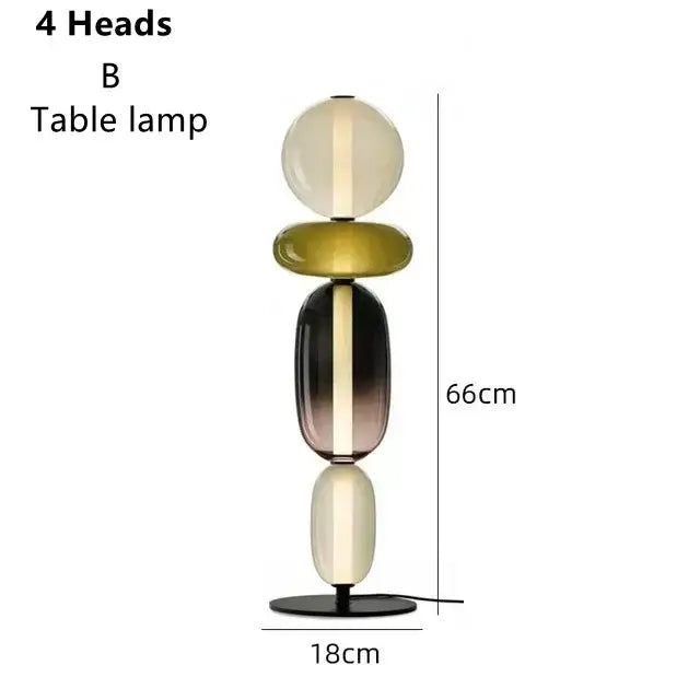 A modern glass floor lamp with four stacked translucent orbs in cream, olive green, and dark gradient hues with led lighting