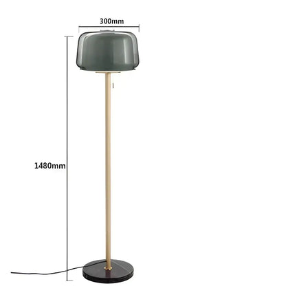 Modern glass floor lamp with a matte dark green glass shade and slender brass-finished pole for living room use