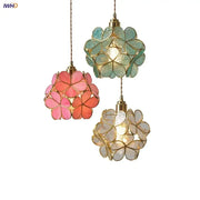 Three hanging pendant lights with glass flower led petals in pink teal and clear suspended by gold chains for dining room
