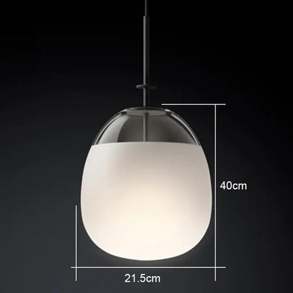 A modern glass flying saucer chandelier pendant light with frosted white globe and clear glass top suspended by black rod
