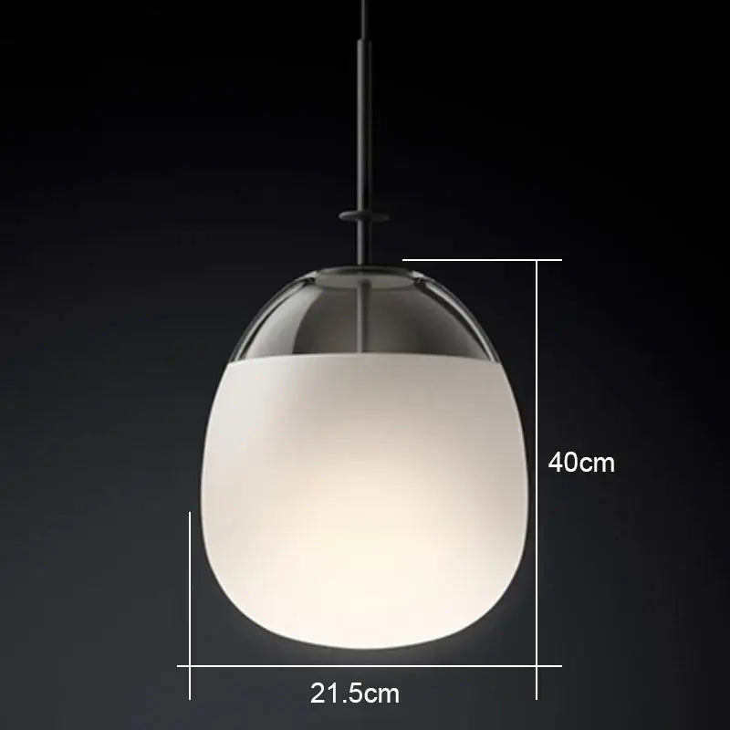 A modern glass flying saucer chandelier pendant light with frosted white globe and clear glass top suspended by black rod