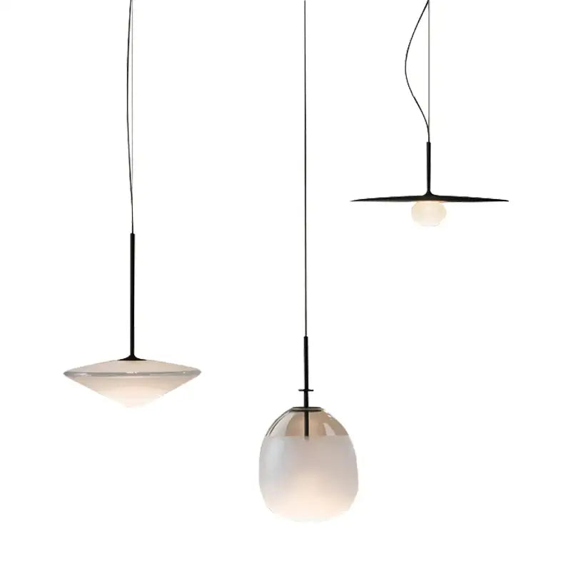 Modern glass flying saucer chandelier with three black metal stems and frosted glass shades in varying shapes