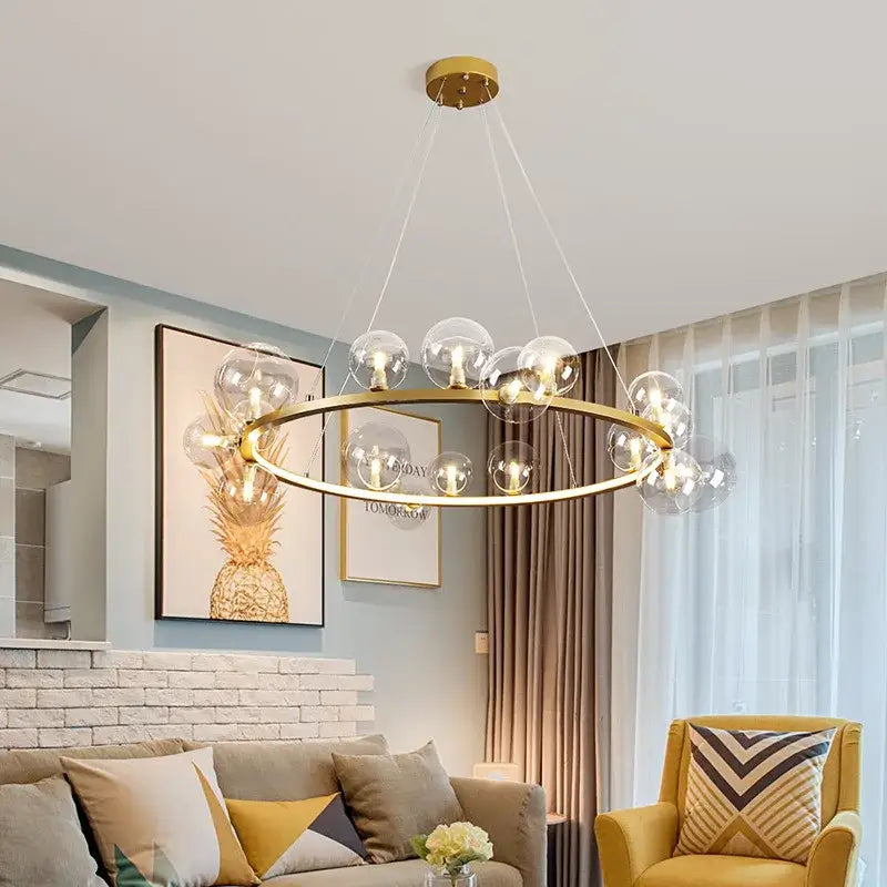Modern gold-toned glass chandelier lamp with clear globe bulbs for kitchen island lighting in black and gold finish