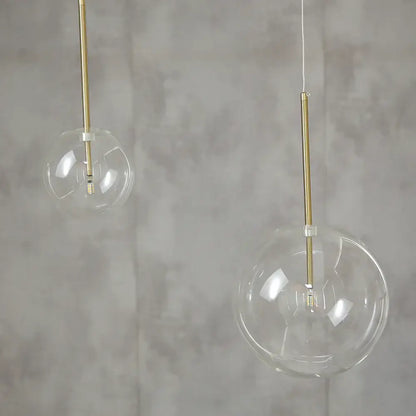 Modern glass globe chrome pendant light featuring clear glass globe pendant lights with slender gold-toned rods