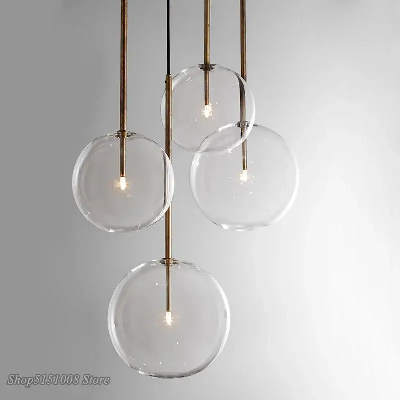 Modern glass globe chrome pendant light with brass-toned metal rods and visible filament bulbs for dining room use