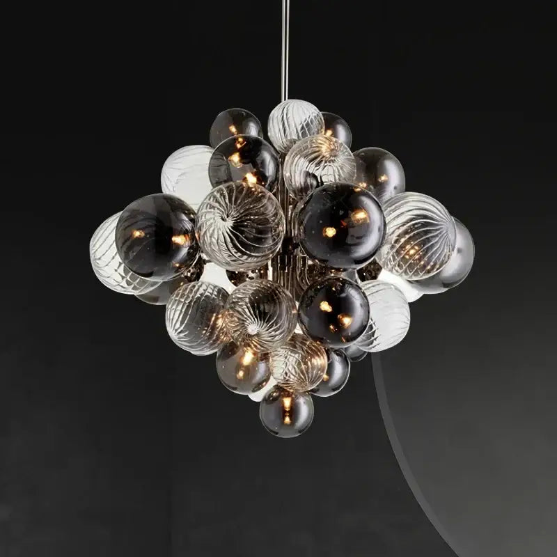 A modern glass globe led chandelier with clear and dark ribbed glass spheres suspended by a sleek metallic rod