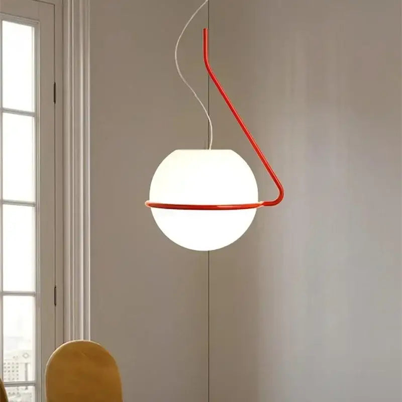 Modern glass globe pendant lamp with a glowing white spherical shade suspended by a curved red arm for kitchen island decorbites glass globe pendant lamp