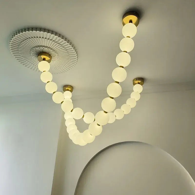 Modern glass gold pendant light featuring frosted glass spheres suspended on gold fixtures for elegant living room decorbites