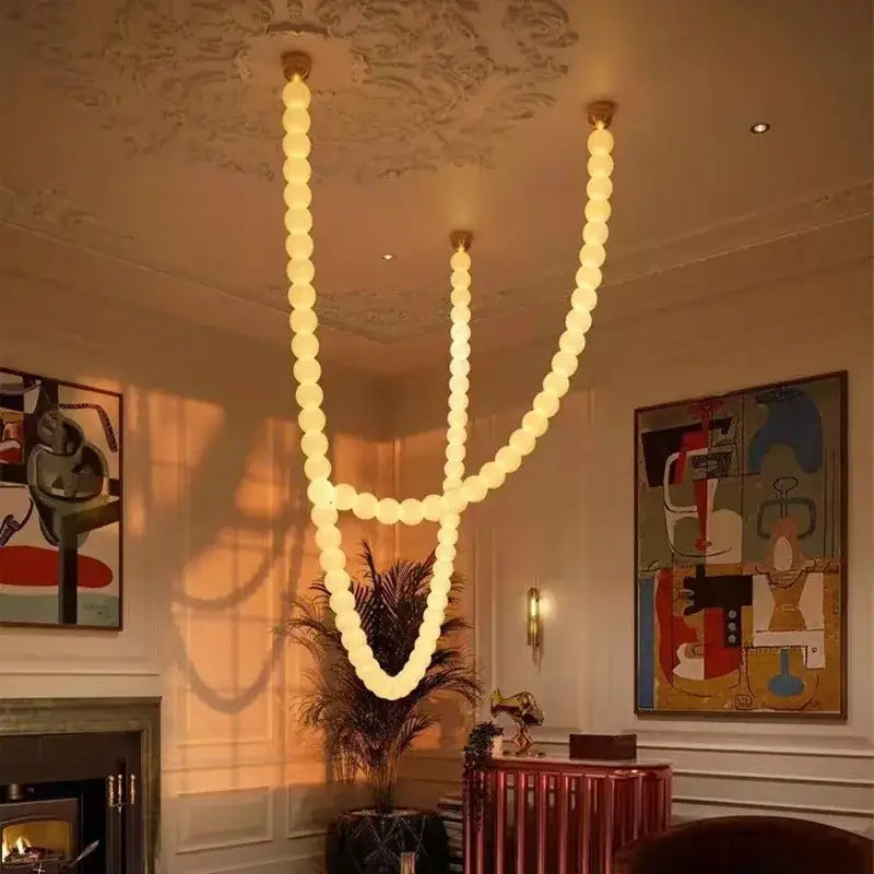 A modern glass gold pendant light with warm spherical bulbs in a flowing v-shaped design for living room decorbites glass gold pendant