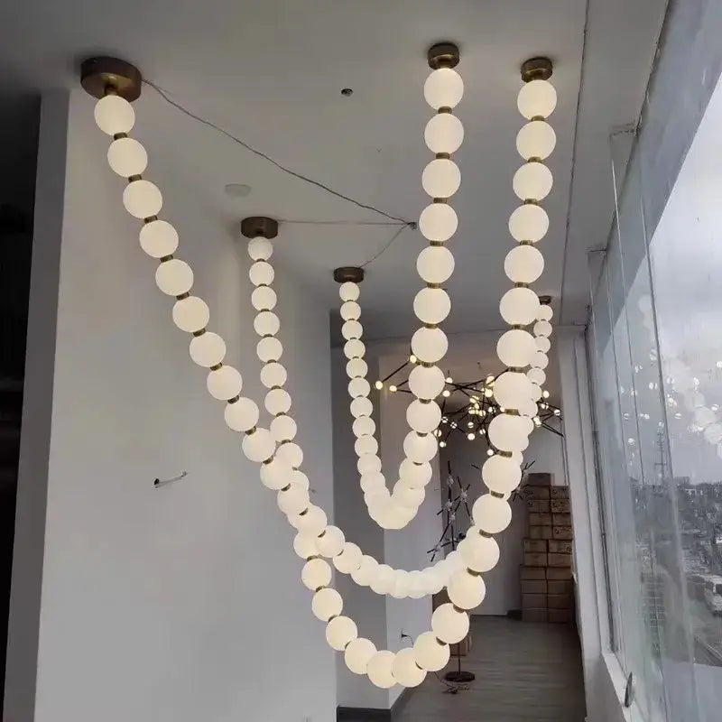 Modern white spherical pendant light with brass fixtures in a v-shaped cascade for decorbites glass gold pendant decor