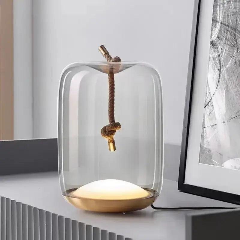 Modern glass knot table lamp with brass base and rope-tied pendant emitting warm light for bedroom decorbites brokis knot