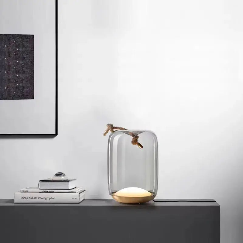 Modern glass knot table lamp with clear glass shade gold brass base and braided rope handle for bedroom decorbites brokis knot