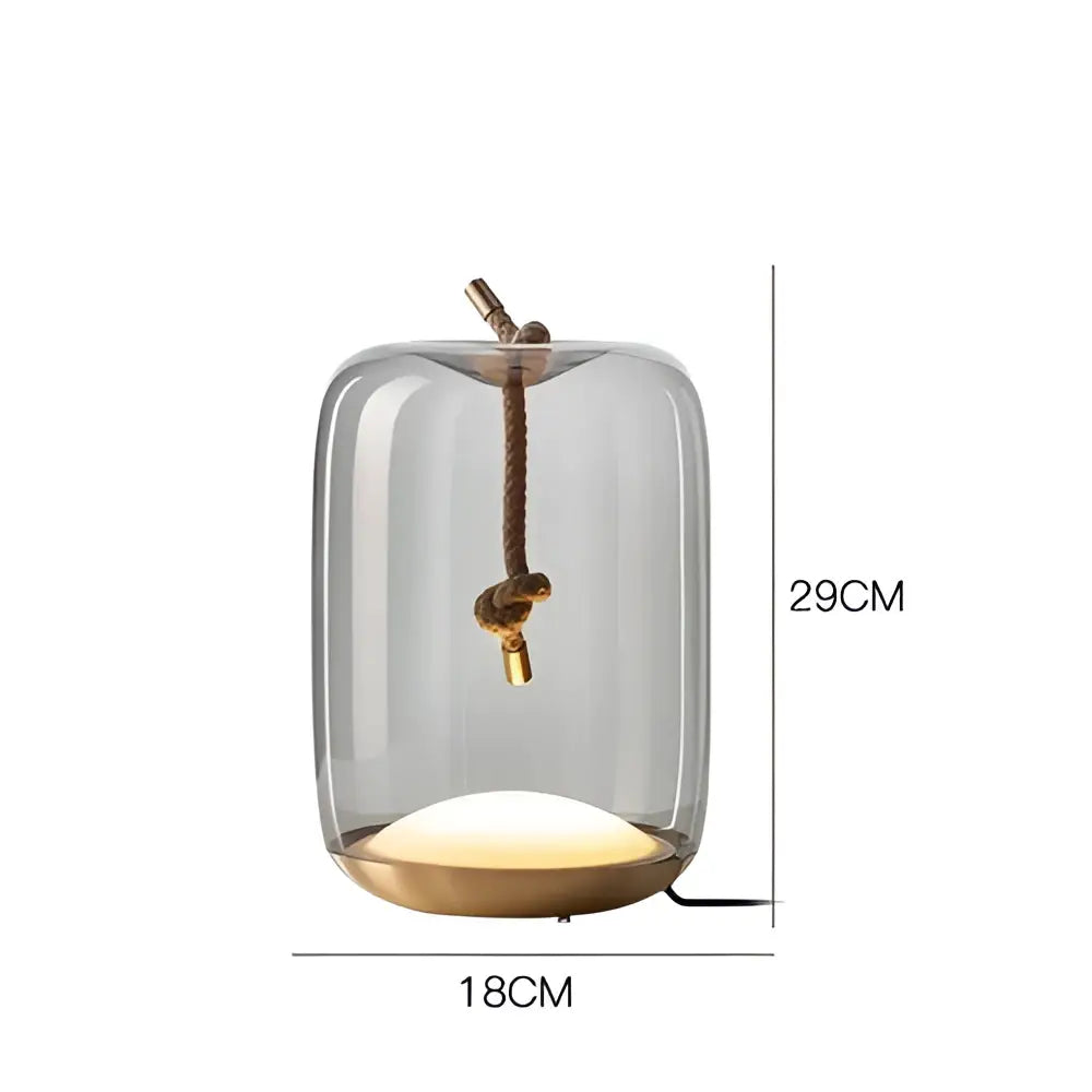 A modern glass knot table lamp with brass base and rope detail featuring warm ambient lighting for bedroom decorbites brokis knot
