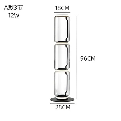 A tall transparent modern glass led floor lamp with three cylindrical sections and black base for living room