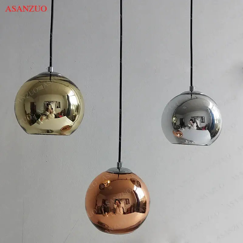 Three spherical modern glass pendant lights in gold rose gold and silver finishes for kitchen lighting