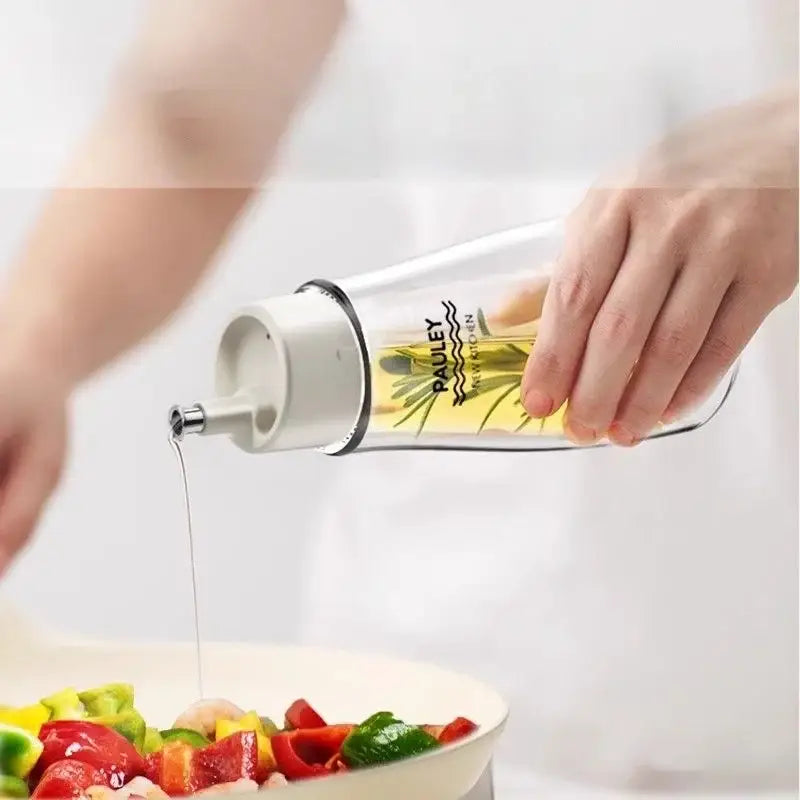 Clear glass seasoning bottle with white plastic cap and spout branded pauley kitchen for modern kitchen use