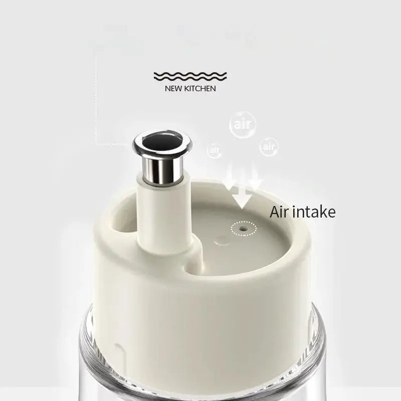 Cream-colored plastic air intake lid with metallic silver spout on a clear glass base in a modern glass seasoning bottle set