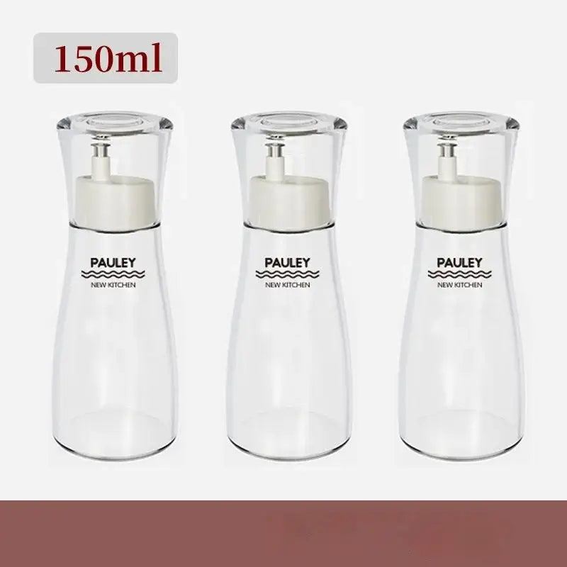 Three transparent glass seasoning bottles with white pump tops in a modern 150ml glass seasoning bottle set