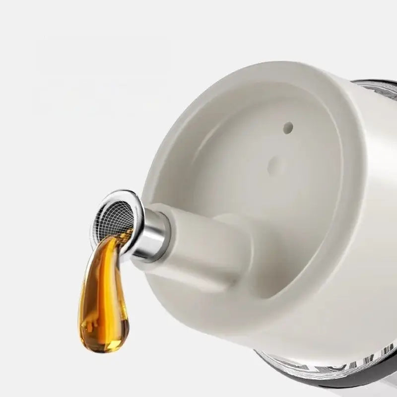 Modern glass seasoning bottle set with white ceramic oil dispenser and silver mesh spout releasing glass seasoning oil