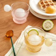 Modern glass coffee mug with transparent body white spherical handle and lemon slice decor