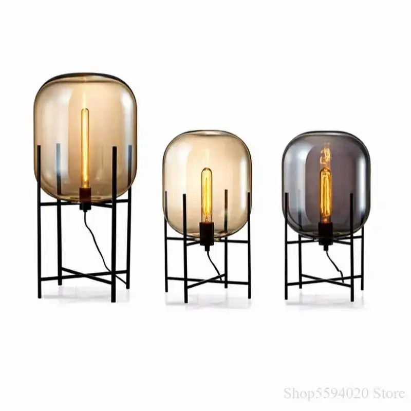 Set of three decorbites glass table lamps with frosted amber and dark gray globes on black metal stands