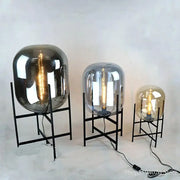 Set of three modern decorbites glass table lamps with black metal stands and exposed filament bulbs for living room decor