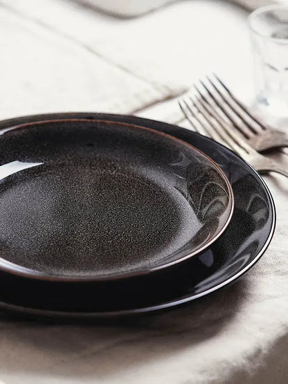Black ceramic round plate with speckled glaze and subtle rim detailing from decorbites ceramic round collection