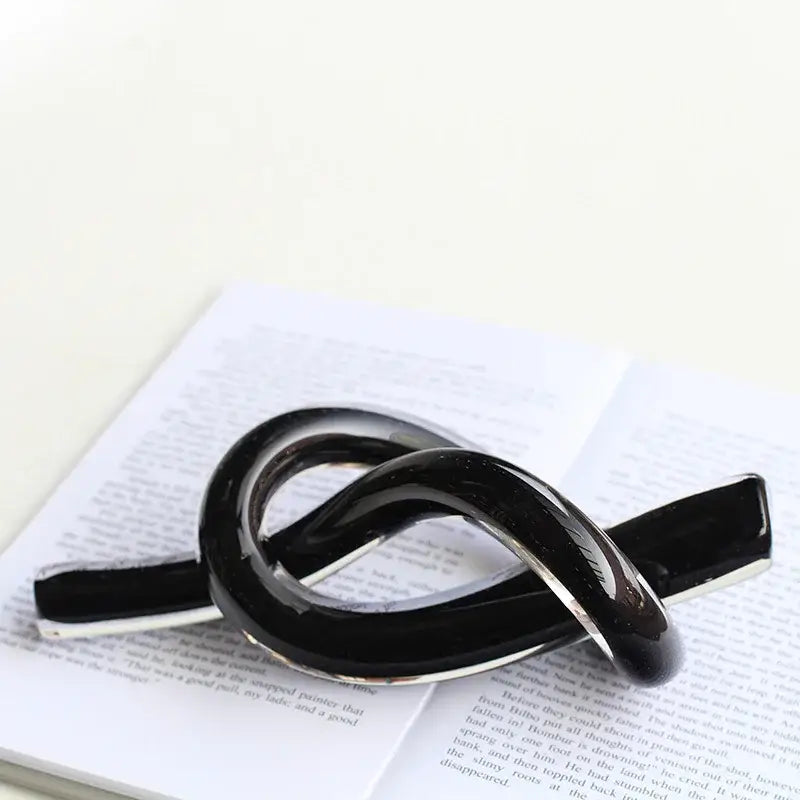 Black glossy enamel pin with silver metal base shaped like elegant infinity knot for decorbites geometric glass decor