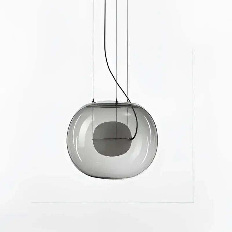 A sleek translucent gray glass ball pendant light with visible wiring from decorbites brokis big for modern dining room decor