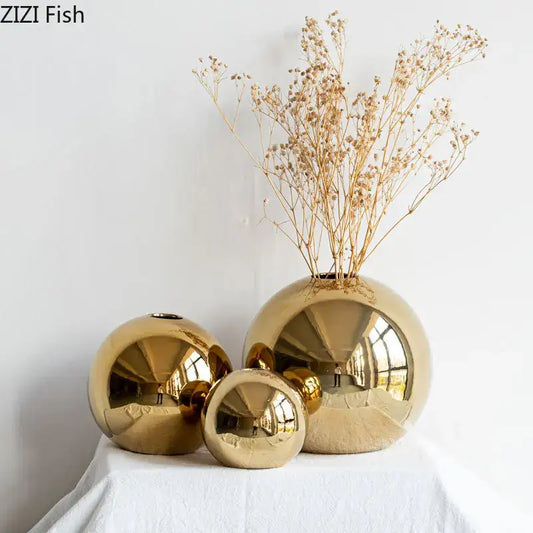 Set of three modern glossy golden ball ceramic vases with reflective surfaces for living room decor by decorbites