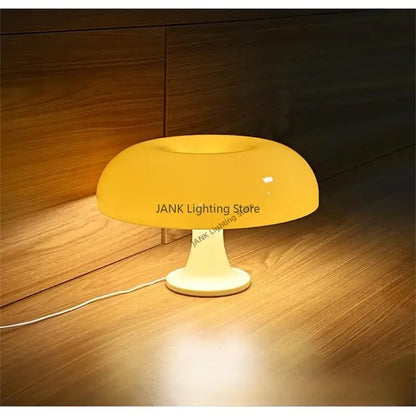 A sleek modern glossy orange led mushroom table lamp with a yellow translucent shade and cream base for bedroom lighting