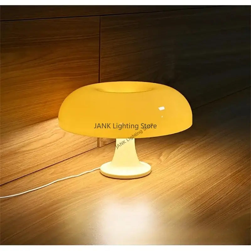 A sleek modern glossy orange led mushroom table lamp with a yellow translucent shade and cream base for bedroom lighting