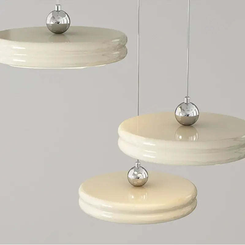 Cream-colored layered circular dimmable pendant light with polished silver accents for modern dining room decorbites pendant light